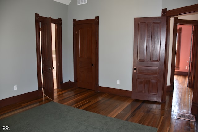 unfurnished bedroom with dark wood-type flooring