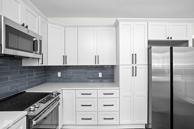 kitchen featuring white cabinetry, light countertops, backsplash, and appliances with stainless steel finishes