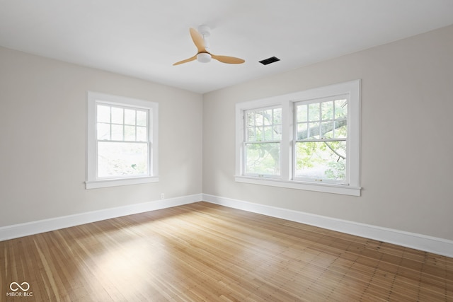 spare room featuring hardwood / wood-style flooring, plenty of natural light, and ceiling fan