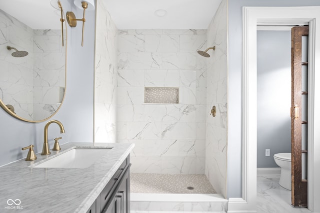 bathroom featuring vanity, toilet, and a tile shower