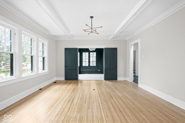 unfurnished living room featuring light hardwood / wood-style flooring, coffered ceiling, an inviting chandelier, and beam ceiling