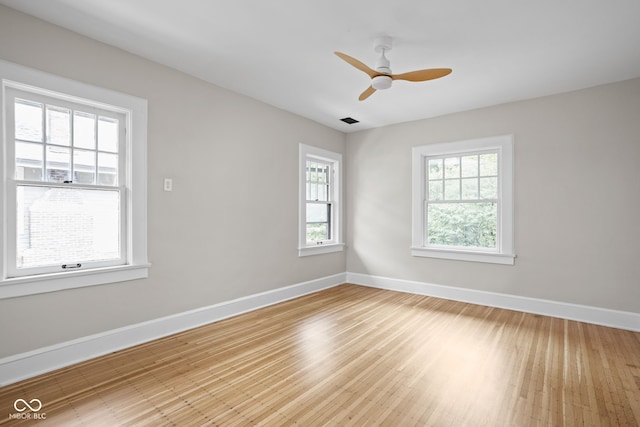 unfurnished room featuring visible vents, baseboards, and wood finished floors