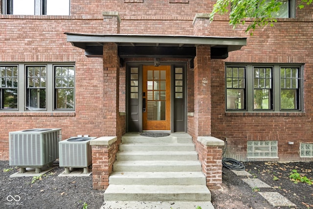 view of exterior entry with covered porch and central air condition unit