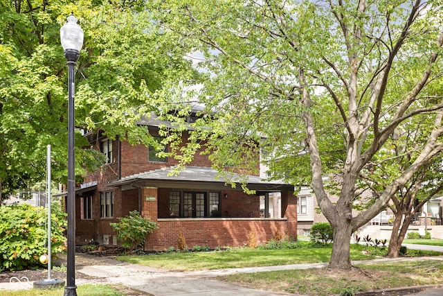 view of front of property featuring brick siding and a front lawn