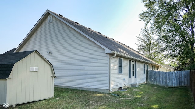 view of property exterior with a storage shed and a lawn