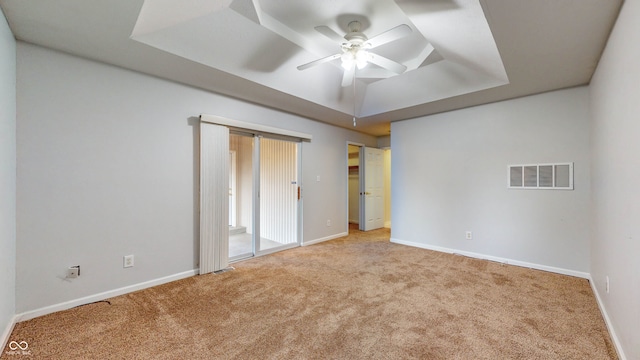 unfurnished bedroom featuring carpet flooring, ceiling fan, and a tray ceiling