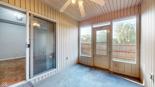 unfurnished sunroom featuring ceiling fan and plenty of natural light