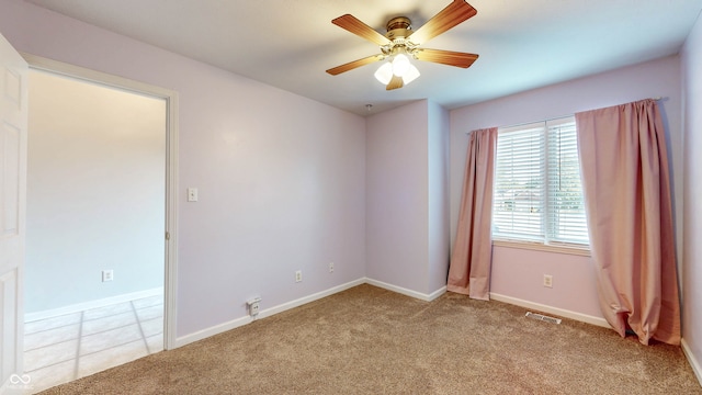 spare room with light colored carpet and ceiling fan