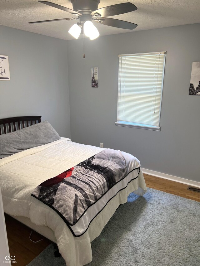 bedroom featuring a textured ceiling, hardwood / wood-style flooring, and ceiling fan