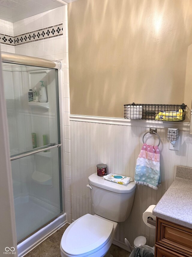 bathroom with vanity, toilet, and a shower with shower door