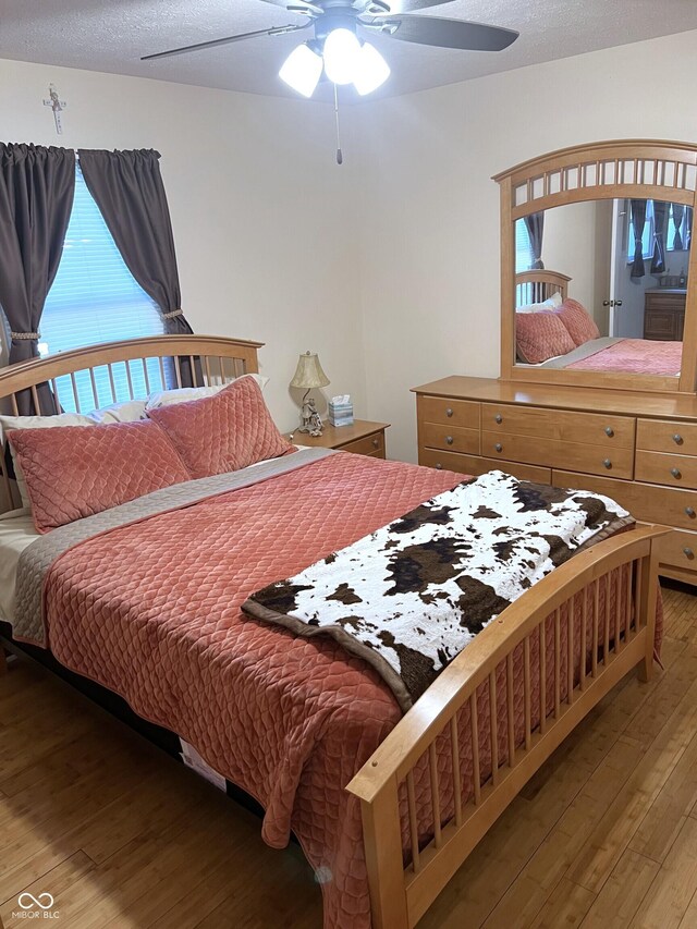 bedroom featuring a textured ceiling, ceiling fan, and hardwood / wood-style floors