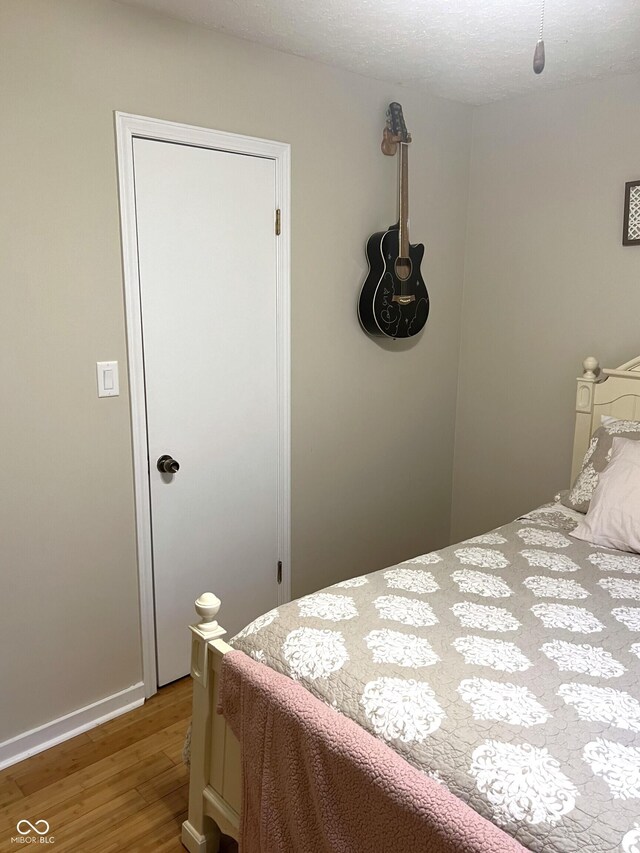 bedroom with a textured ceiling and light hardwood / wood-style flooring