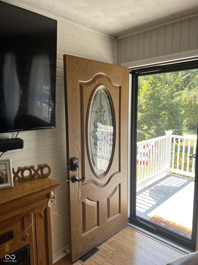 foyer with hardwood / wood-style flooring and wood walls