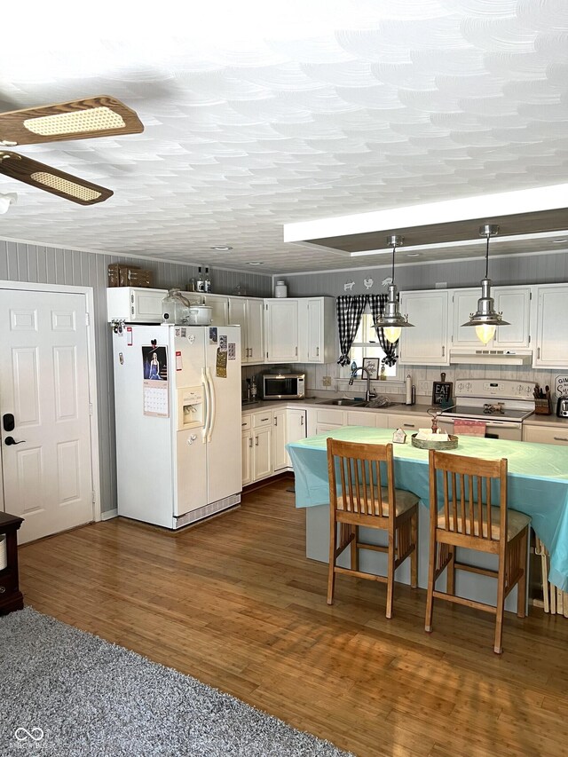 kitchen featuring sink, white appliances, dark hardwood / wood-style flooring, and white cabinets