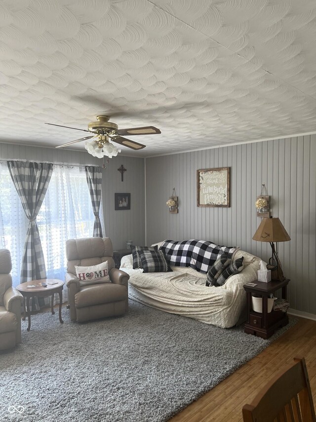 living room with hardwood / wood-style floors, ceiling fan, and a textured ceiling