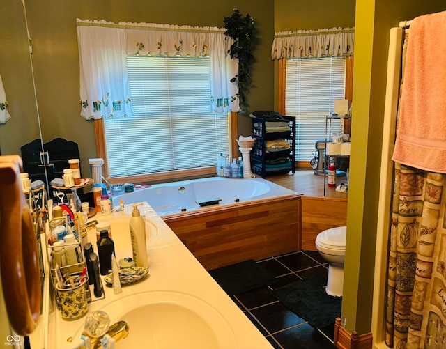 bathroom featuring tile patterned floors, a washtub, vanity, and toilet