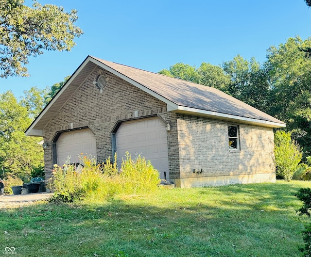 view of side of property with a lawn, an outbuilding, and a garage