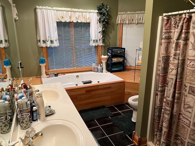 bathroom featuring tile patterned floors, vanity, toilet, and a washtub