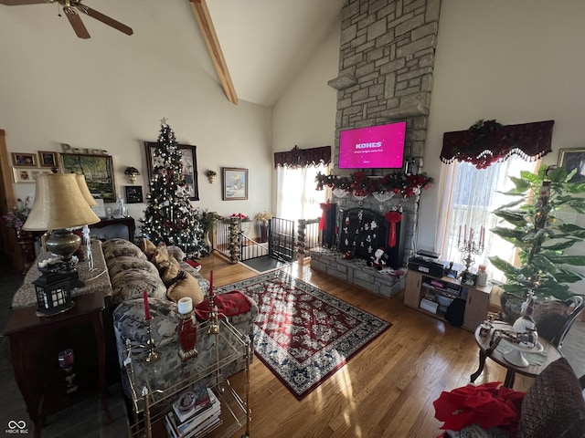 living room featuring beam ceiling, hardwood / wood-style flooring, high vaulted ceiling, and ceiling fan