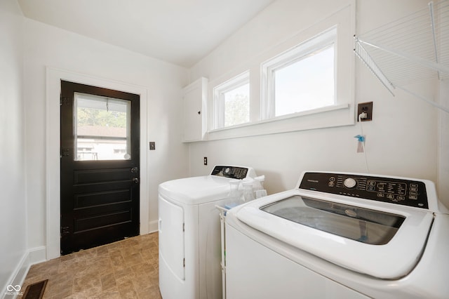 laundry room with washing machine and clothes dryer and cabinets