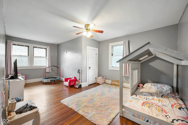 bedroom with multiple windows, dark hardwood / wood-style flooring, and ceiling fan