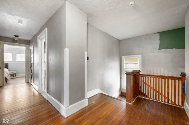 hallway featuring a textured ceiling and hardwood / wood-style floors