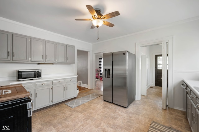 kitchen featuring gray cabinets, ornamental molding, ceiling fan, and stainless steel appliances