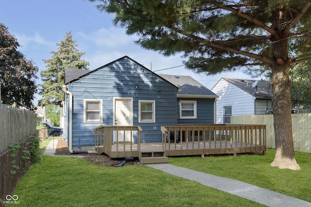 rear view of house with a deck and a lawn