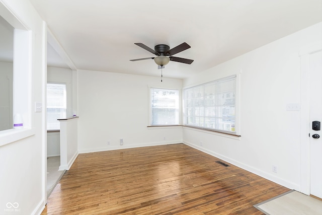 empty room with ceiling fan and hardwood / wood-style flooring