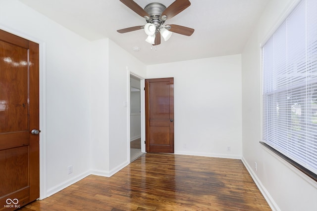 unfurnished room with dark hardwood / wood-style flooring and ceiling fan