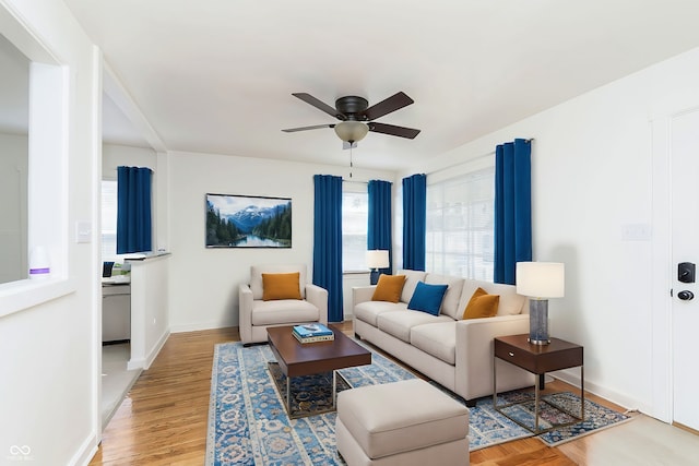 living room featuring light hardwood / wood-style flooring and ceiling fan