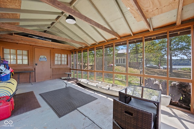 sunroom / solarium featuring a water view and vaulted ceiling