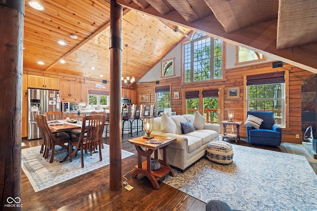 living room featuring high vaulted ceiling, wood-type flooring, a chandelier, and plenty of natural light