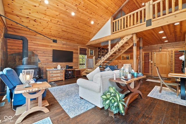 living room with wood ceiling, high vaulted ceiling, a wood stove, wooden walls, and dark hardwood / wood-style floors