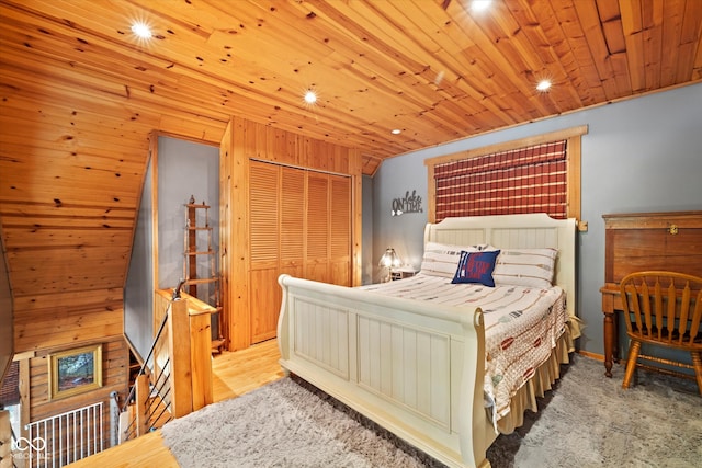 bedroom featuring wood ceiling, wood walls, a closet, and light hardwood / wood-style flooring