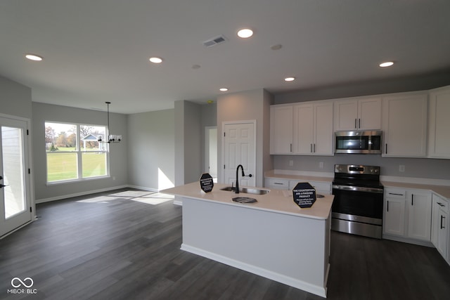 kitchen featuring stainless steel appliances, white cabinetry, sink, hanging light fixtures, and a kitchen island with sink