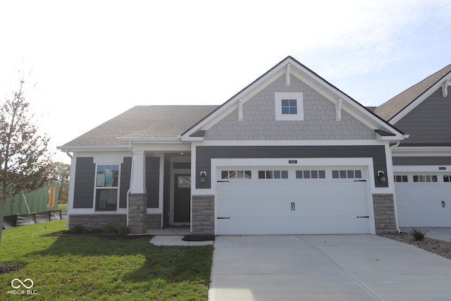 craftsman house featuring a front lawn and a garage