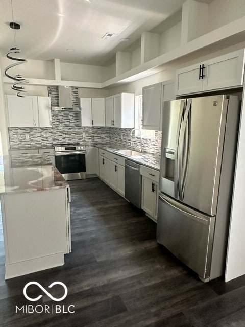 kitchen with white cabinetry, sink, appliances with stainless steel finishes, decorative light fixtures, and dark hardwood / wood-style flooring