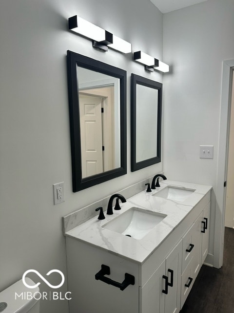 bathroom featuring wood-type flooring, toilet, and vanity