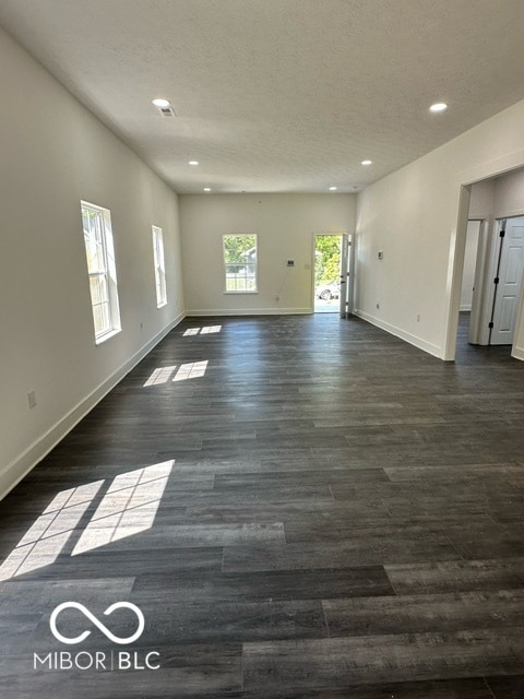 unfurnished living room with dark hardwood / wood-style floors and a textured ceiling