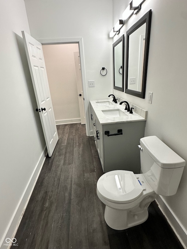 bathroom with hardwood / wood-style flooring, vanity, and toilet