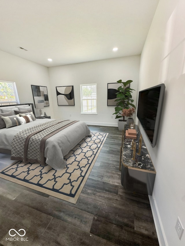 bedroom with dark wood-type flooring and multiple windows