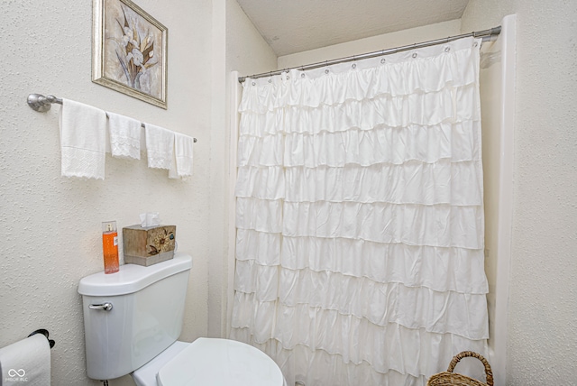 bathroom featuring a shower with shower curtain and toilet