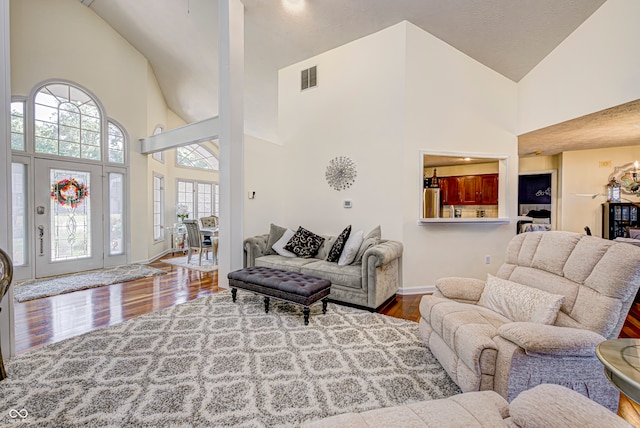 living room with high vaulted ceiling and wood-type flooring