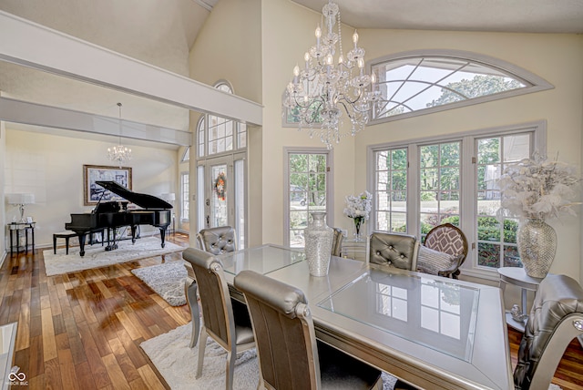 dining area featuring a notable chandelier, hardwood / wood-style floors, and high vaulted ceiling