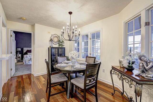 dining room with a textured ceiling, an inviting chandelier, and wood-type flooring