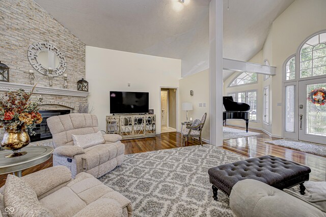 living room featuring a fireplace, high vaulted ceiling, plenty of natural light, and wood-type flooring