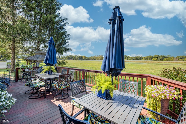 wooden terrace featuring a yard and a rural view