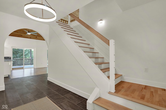 stairs with hardwood / wood-style floors, ceiling fan, and wood ceiling