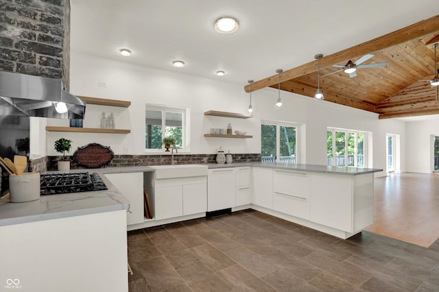 kitchen featuring white cabinetry, a healthy amount of sunlight, ceiling fan, and vaulted ceiling with beams